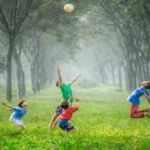 4 kids in a forest playing volleyball